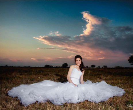 bride seeted in veld at sunset